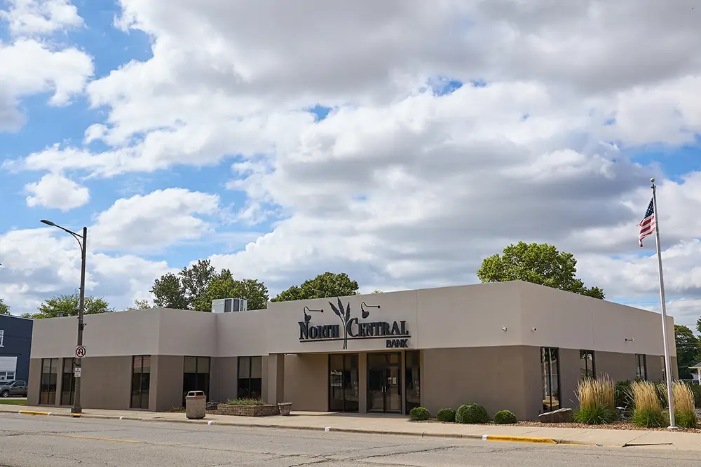 A tan and cream colored building with the North Central Bank logo over the doorway.